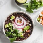 This slow cooker black bean soup is full of hearty Tex-Mex flavors and uses dried black beans that don't require soaking. Perfect hands-off recipe for fall, winter, cold weather months, or anytime you want to use a crock pot instead!