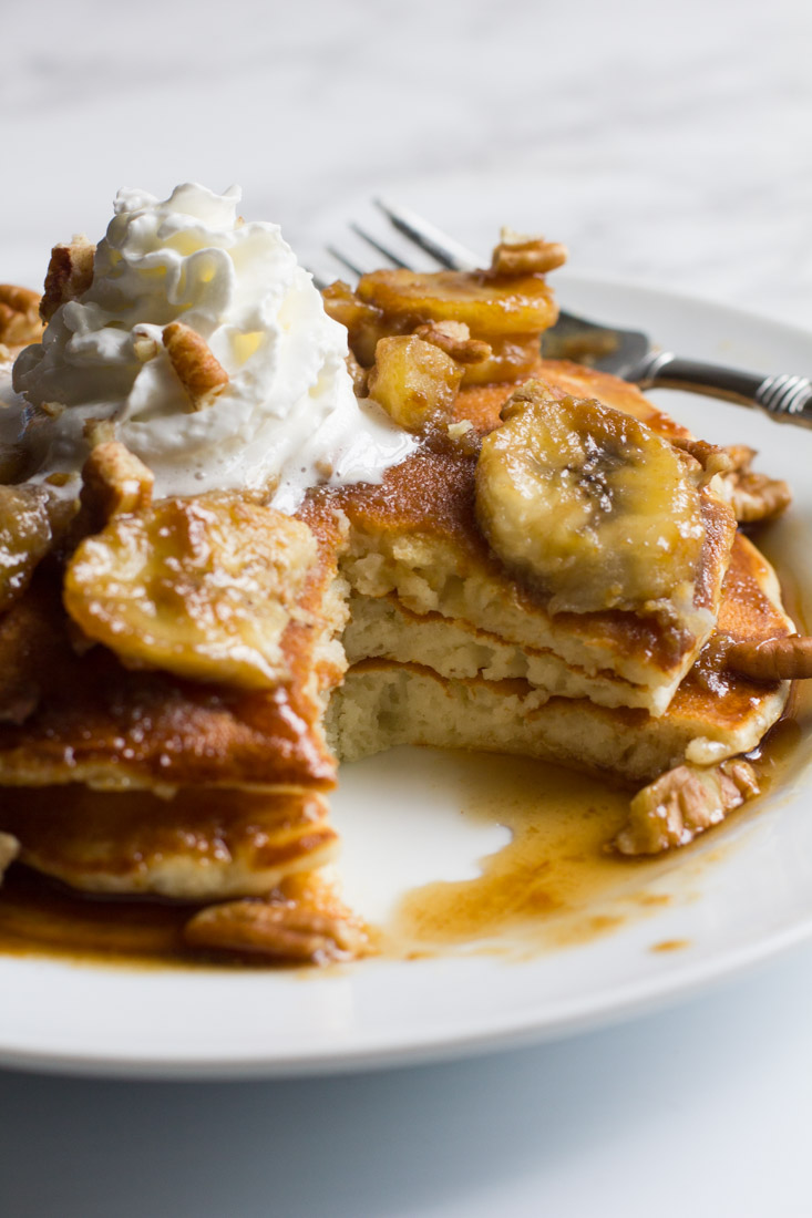 The breakfast in bed of your dreams, these bananas foster pancakes are topped with a rich caramel sauce and served with pecans, whipped cream or vanilla ice cream.