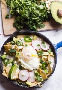 Chilaquiles verdes are a tex-mex brunch mainstay. Tossed in salsa verde and topped with an egg, cream and cheese, they're the perfect way to start your day.