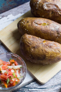 These easy baked potatoes are topped with a slow cooked Tex Mex style pulled pork, cheese, pico de gallo and jalapeno ranch. A hearty and easy to prepare meal!