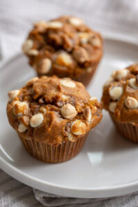 bakery style white chocolate chip pumpkin muffins on a white plate