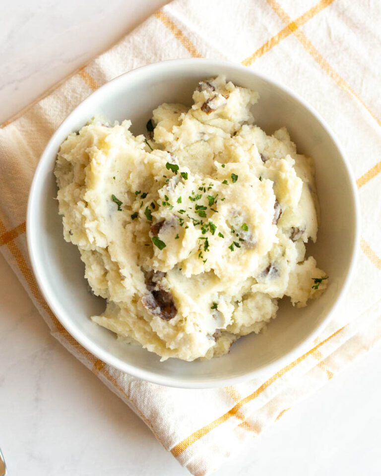 mashed potatoes in a white bowl on a kitchen towel