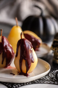 Easy Poached Pears on a plate with red velvet sauce