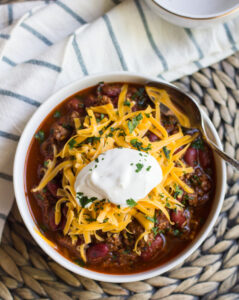 Instant Pot chili in a bowl with cheese and sour cream