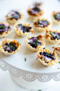 blueberry goat cheese appetizer bites in phyllo dough on a serving dish