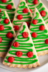 christmas tree cookies on a plate with red and green icing