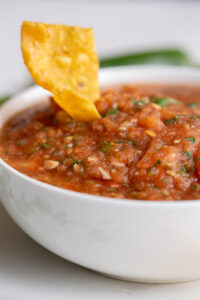 roasted red salsa with a chip sticking out the top