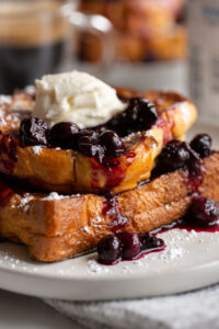 stuffed french toast with blueberry sauce and whipped cream on top