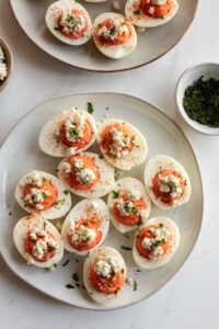 buffalo deviled eggs on a plate topped with blue cheese