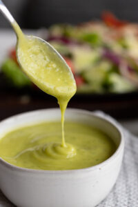 avocado lime dressing dripping into a bowl