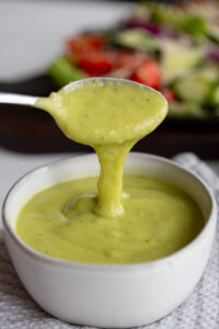 creamy avocado lime dressing being poured out