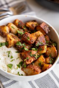 spicy roasted potatoes in a bowl with honey and ricotta