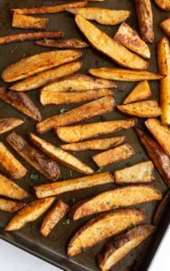 Seasoned potato wedges on a sheet pan