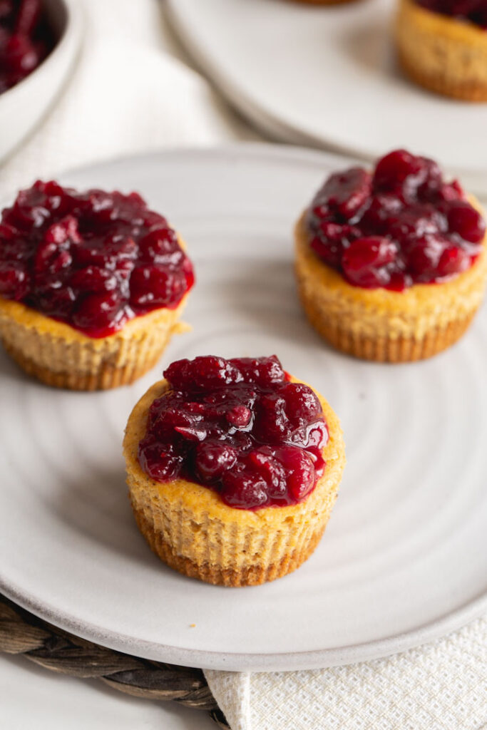 mini pumpkin cheesecakes with a cranberry compote on a plate