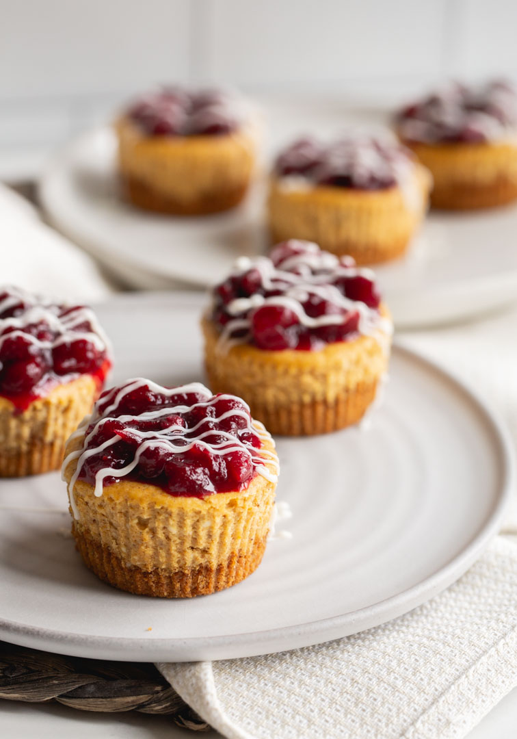 mini pumpkin cheesecakes topped with a cranberry compote and white chocolate