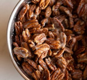 pecans in a bowl tossed with egg whites and vanilla