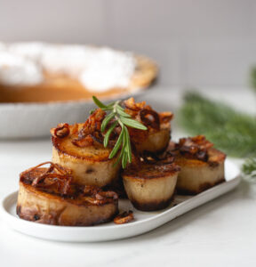 fondant potatoes garnished with fried shallots and rosemary