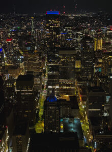 nighttime view of downtown Seattle from a tall building, including the space needle in the background
